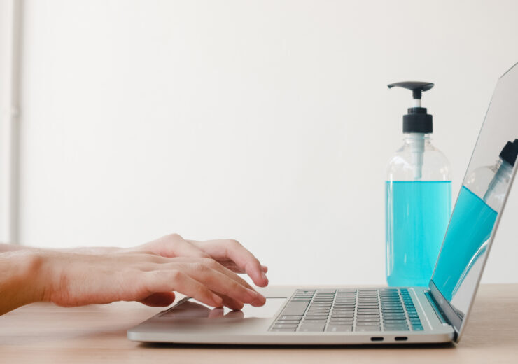 Asian woman using alcohol gel sanitizer wash hand before work on